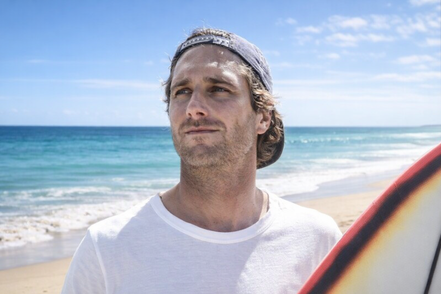 Romain Laulhé, surfeur professionnel français et sextuple champion de France, sur une plage du Pays basque avec sa planche de surf