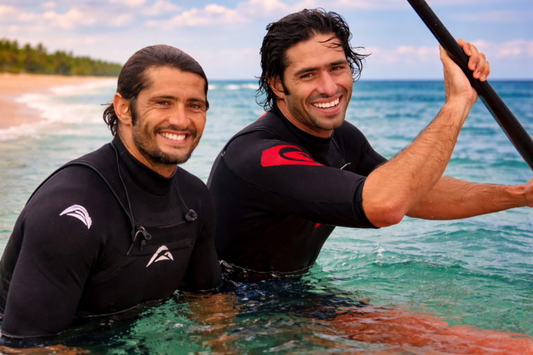 Peyo Lizarazu et son frère aîné Bixente Lizarazu en combinaison de surf dans l'eau au Pays basque